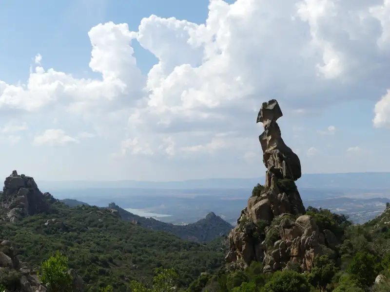 Bizarre Felsformation in einer hügeligen Landschaft.