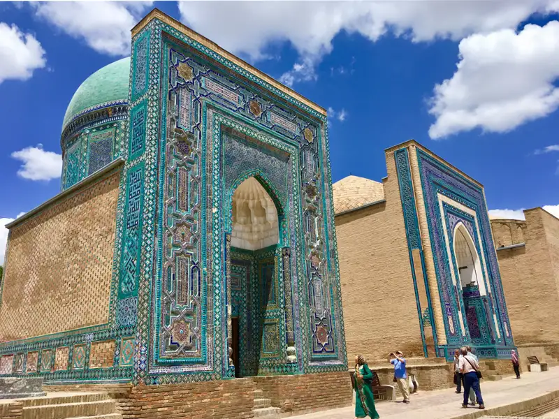 Türkisfarbene Mosaikfassade eines Mausoleums mit kunstvollen Mustern und Verzierungen.