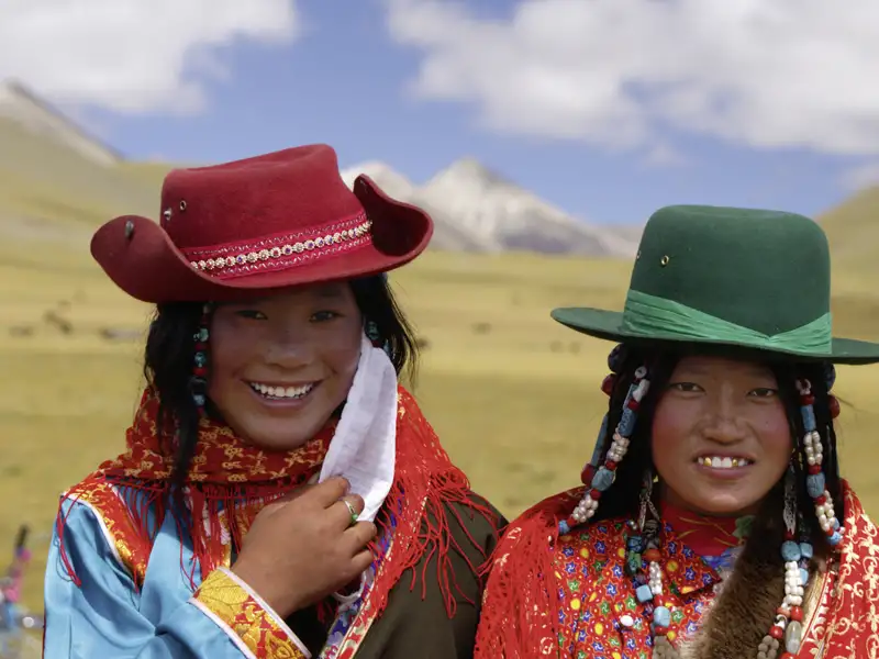 Zwei Frauen in traditioneller Kleidung und Hüten, die die lokale Kultur repräsentieren.