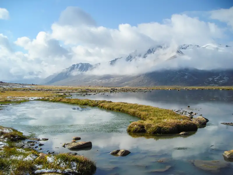Bergsee mit Wolkenverhangenen Gipfeln