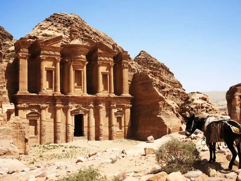 Das Kloster in Petra, aus dem Felsen gehauen, mit einem Esel im Vordergrund.