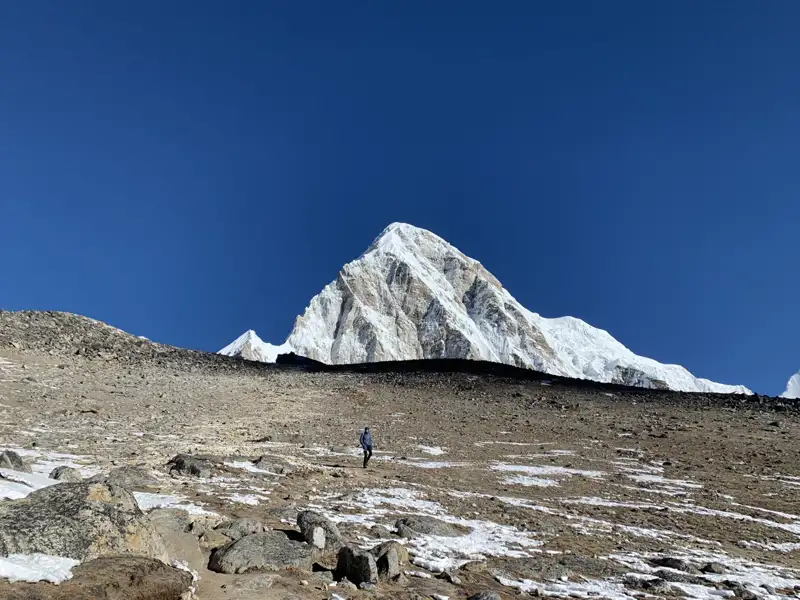 Wanderer auf dem Weg zu einem schneebedeckten Berggipfel.