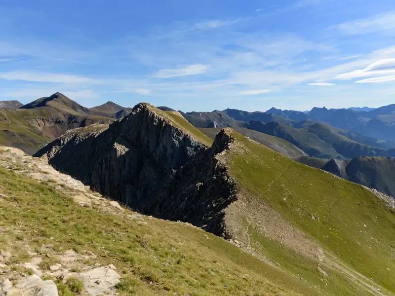 Berggipfel und -täler unter blauem Himmel.