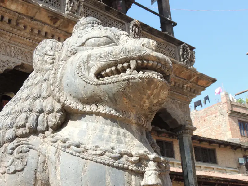 Steinskulptur eines Löwen, der einen Tempel bewacht.