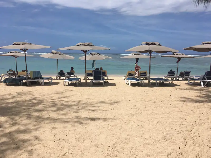 Strand mit Liegestühlen und Sonnenschirmen.