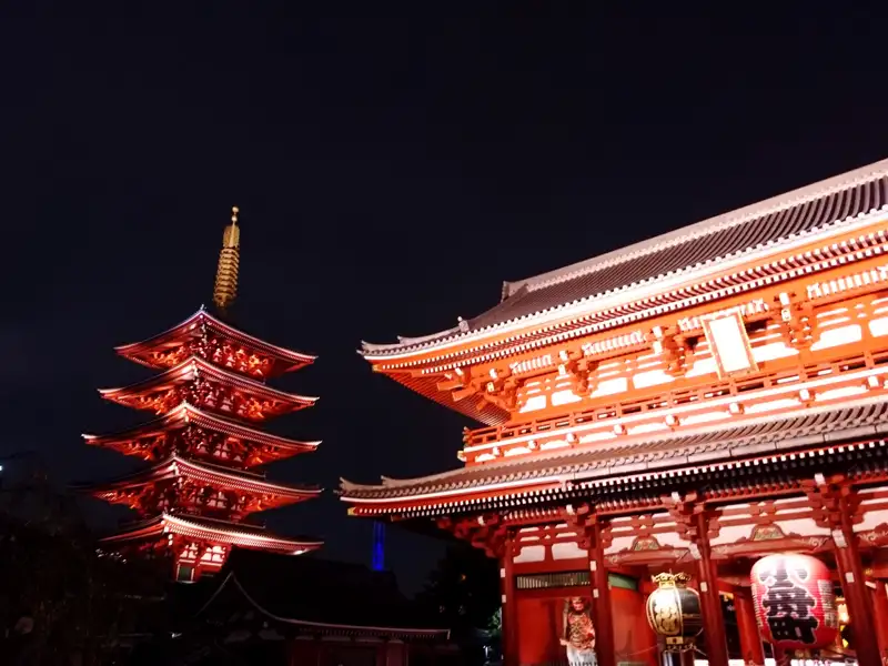 Nachtansicht eines beleuchteten Tempels und seiner Pagode.