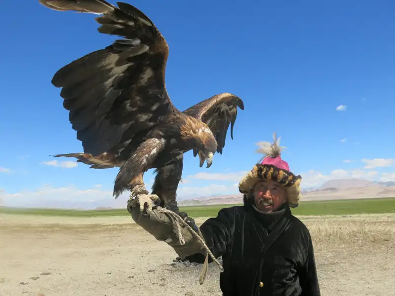 Ein Mann mit einem Steinadler auf dem Arm.