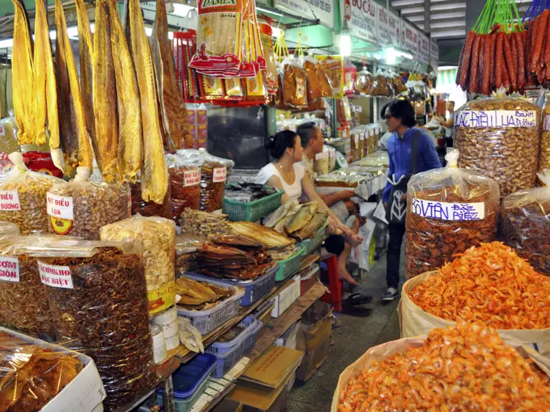 Getrocknete Fische, Garnelen und andere Lebensmittel werden auf einem geschäftigen Markt verkauft.