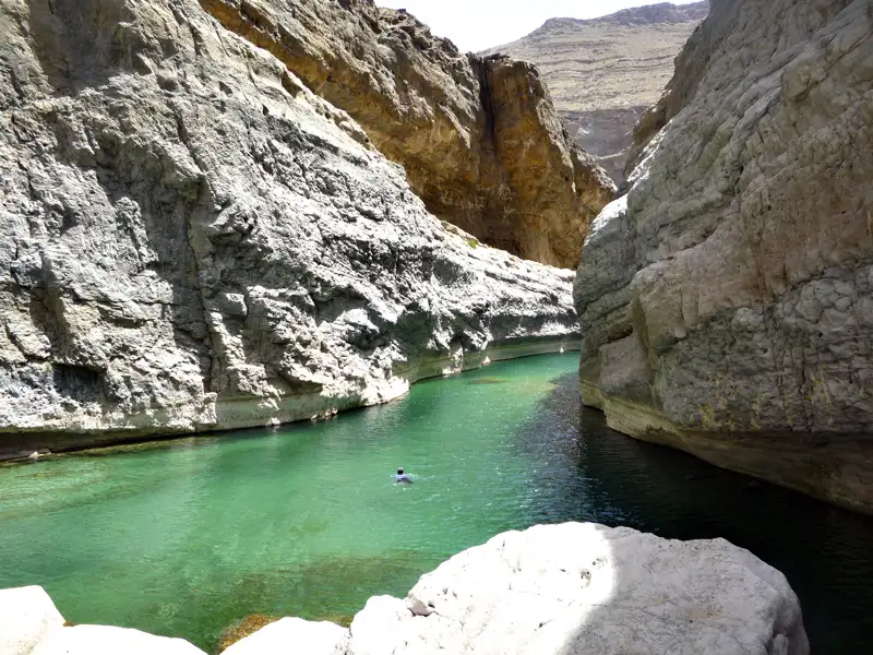 Ein Schwimmer genießt das erfrischende Wasser in einer tiefen Schlucht.