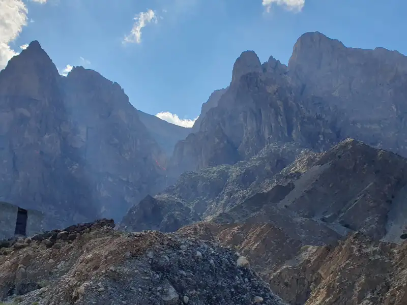 Felsige Berglandschaft mit steilen Gipfeln unter blauem Himmel.
