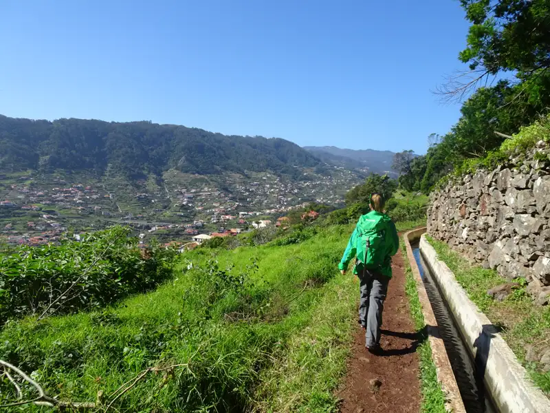 Wanderer auf einem Levada-Weg mit Blick auf das Tal.