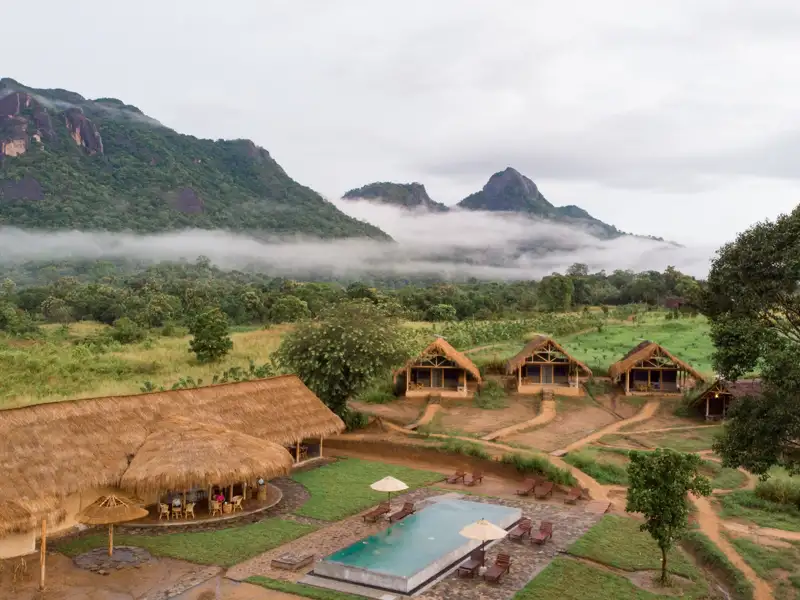 Unterkunft mit Pool und Blick auf die bewaldeten Berge im Nebel.