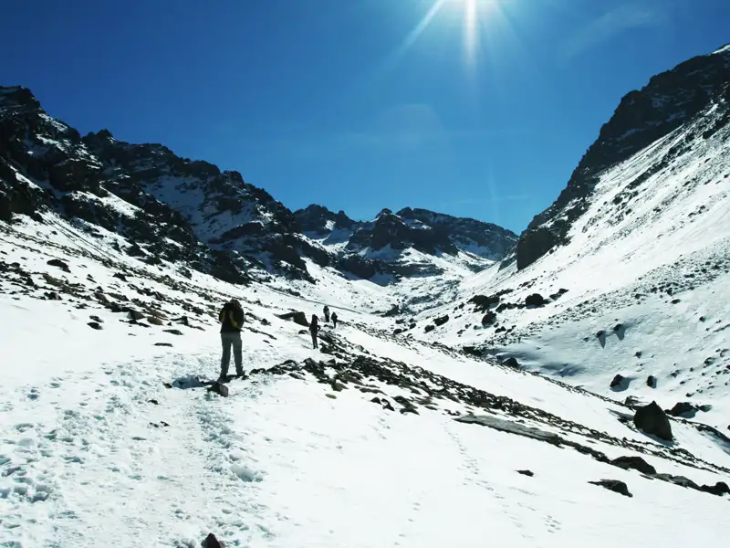Wanderer auf einem verschneiten Bergpfad.